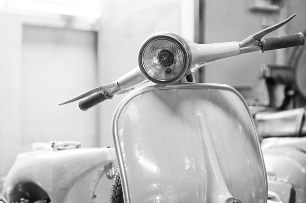 Monochrome shot of a vintage scooter with shallow depth of field