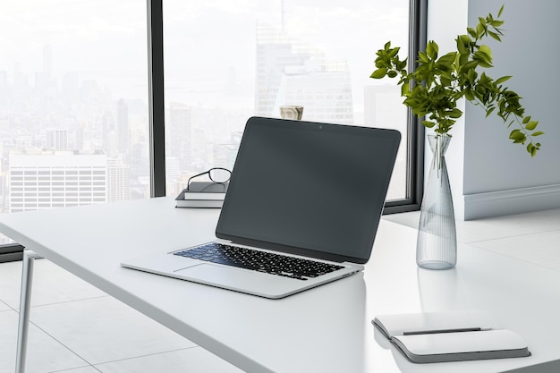 Monochrome style work place with black laptop monitor with copyspace on marble tabletop glass vase with plant and city view from big window 3D rendering mock up