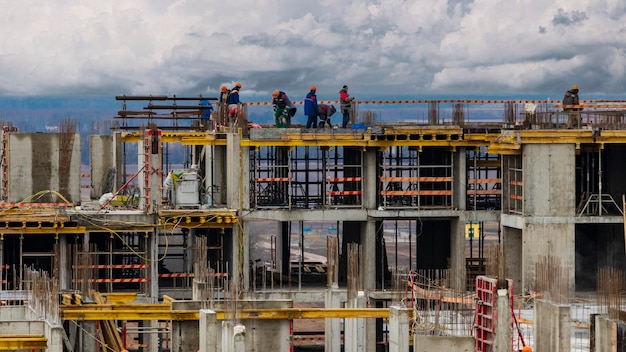 Costruzione a telaio monolitico dell'edificio operai che lavorano nel cantiere a casa la struttura per le pareti cassaforma per pareti in cemento primo piano