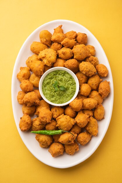 Monsoon special Moong Dal Vada, Pakoda, Dalwada, Pakora or Mungdal Bhajiya or Yellow Split Gram Fritters Served with Green Chutney