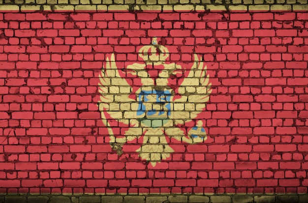 Montenegro flag is painted onto an old brick wall