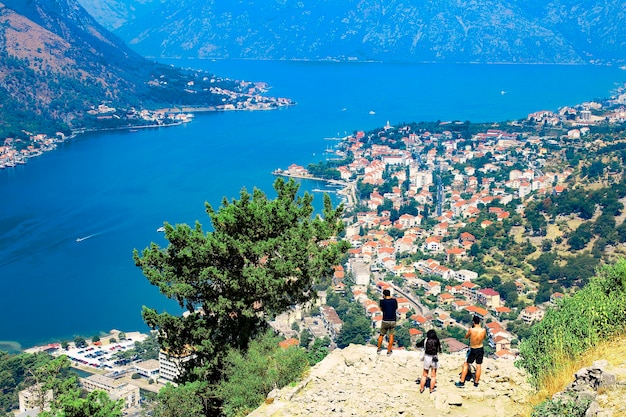 Montenegro-toeristen bewonderen het uitzicht op de baai-huizen met rode daken