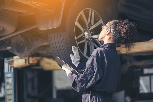 Monteur onderzijde bij autoservice, autoreparatieservice te onderzoeken.