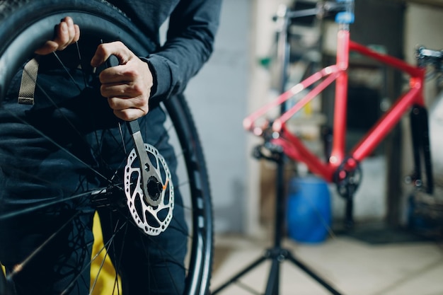 Monteur reparateur assembleren wiel draai moersleutel schijfrem aangepaste fiets in werkplaats