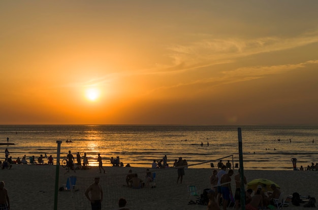 Foto montevideo uruguay 11 januari 2022 prachtige zonsondergang op het strand van ramires met zwemmers op een zomer