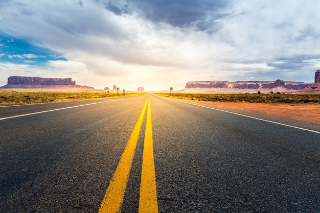 Monument Valley Road naar de horizon bij zonsondergang.