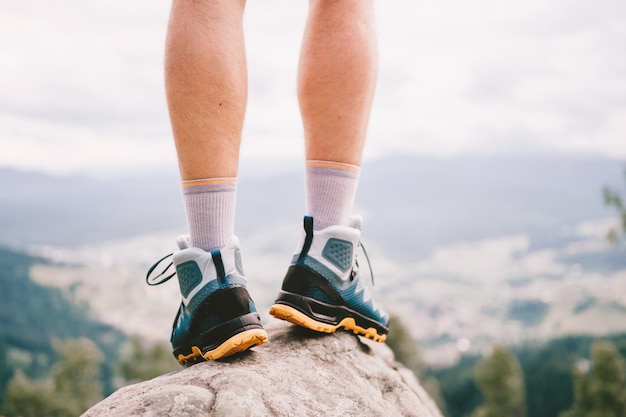 Mood photo of male legs wearing sportive hiking shoes with strong protective sole.