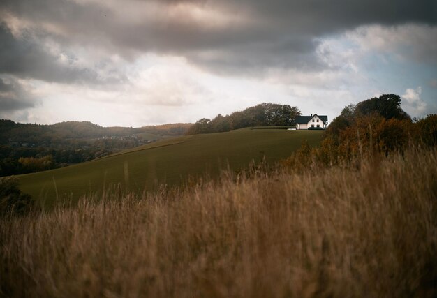 Moody landscape with a single house on the field Concept of living in a beautiful place in the countryside