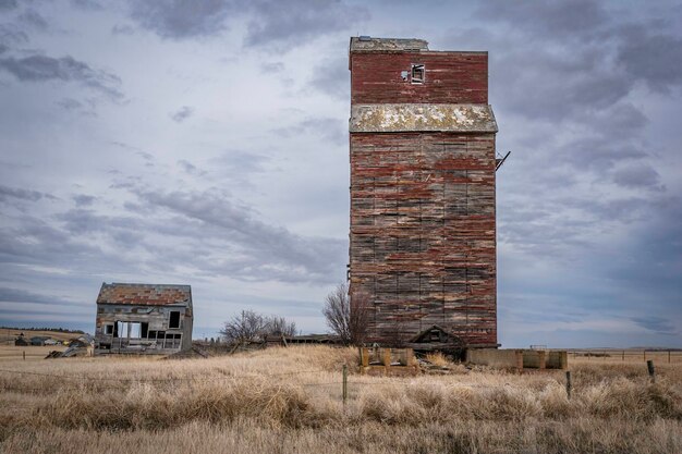 Moody skies over an old grain elevator and its office in Neidpath Saskatchewan Canada