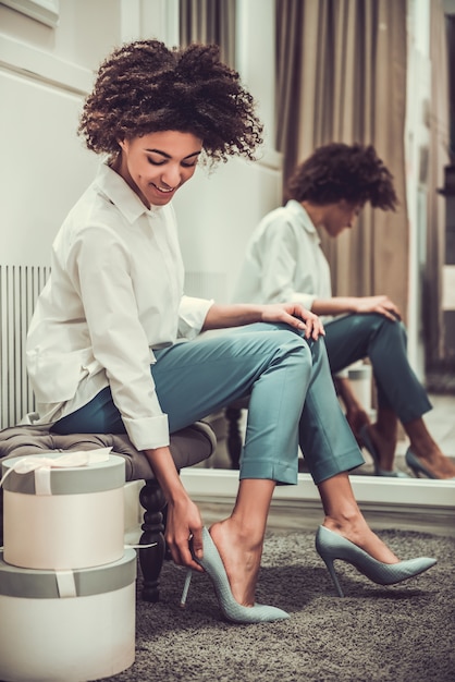 Mooi Afro-Amerikaans meisje probeert schoenen met hoge hakken.