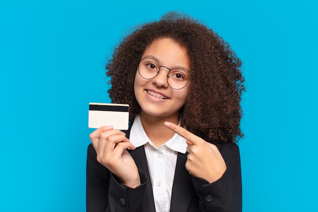 Mooi afro-tiener bedrijfsmeisje met een creditcard. online winkelconcept