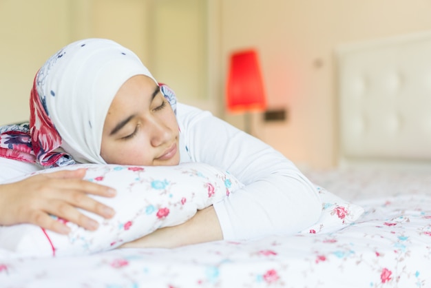 Mooi Arabisch meisje op bed in moderne slaapkamer