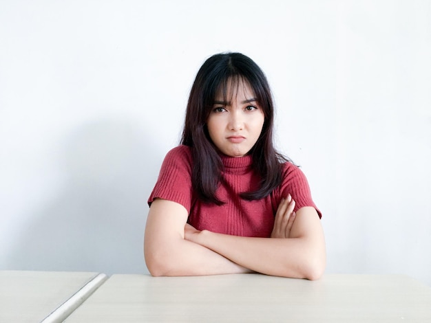 Mooi Aziatisch meisje is boos en boos met gevouwen armen geïsoleerd op een witte achtergrond