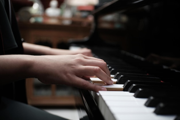 Mooi Aziatisch meisje leert piano spelen