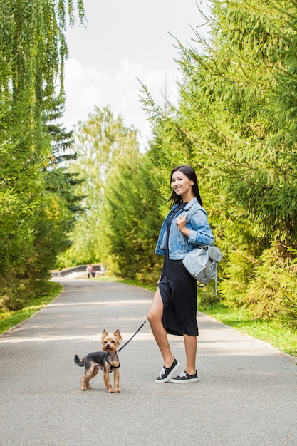 Mooi Aziatisch meisje voor een wandeling in het park in de zomer met haar hond Yorkshire Terrier