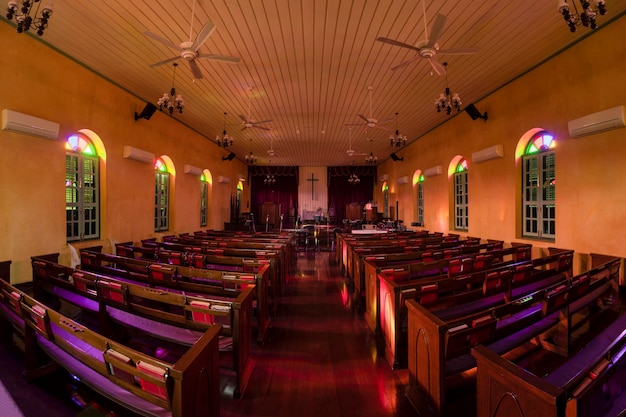 Foto mooi binnenaanzicht van kleine landkerk met lege houten kerkbanken.