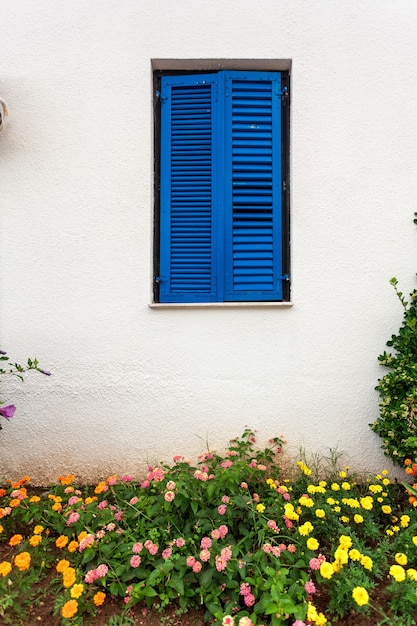 Mooi blauw raam in Griekse stijl bij oud huis