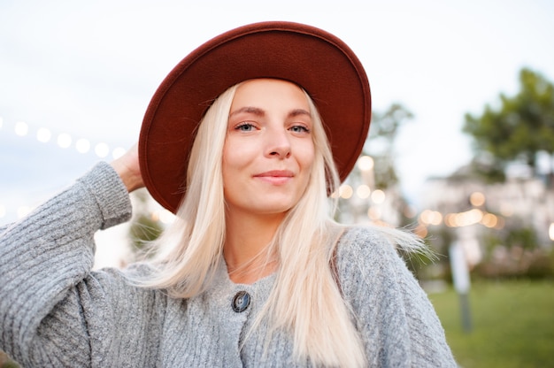 Mooi blond lachend meisje draagt vrijetijdskleding en hoed