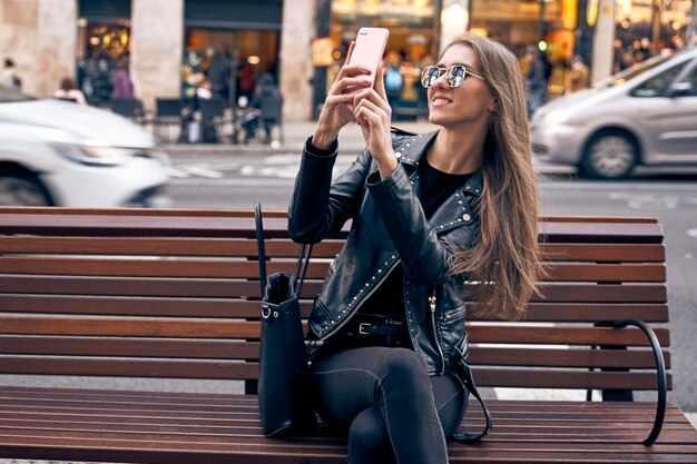 Foto mooi blond meisje dat een zelfportret maakt met haar telefoon