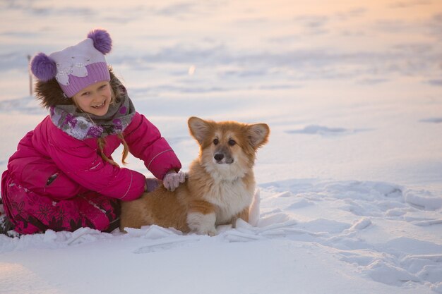 Mooi blond meisje en corgi pluizig puppy op de winterdag