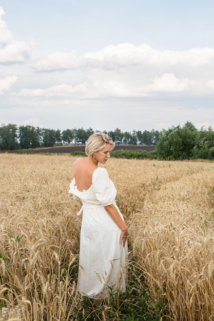 Mooi blond meisje in een tarweveld