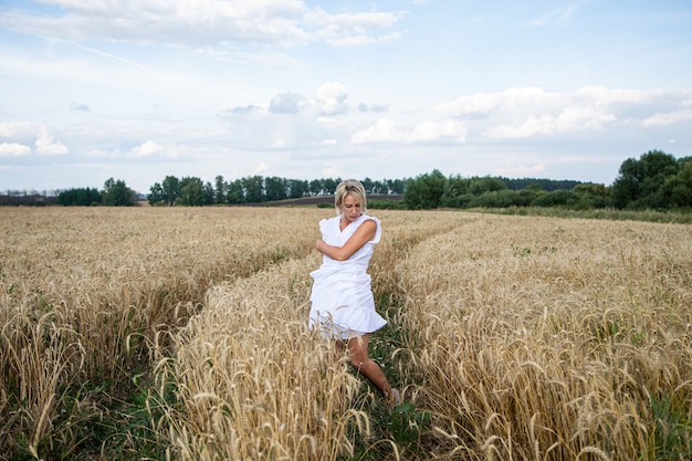 Mooi blond meisje in een tarweveld