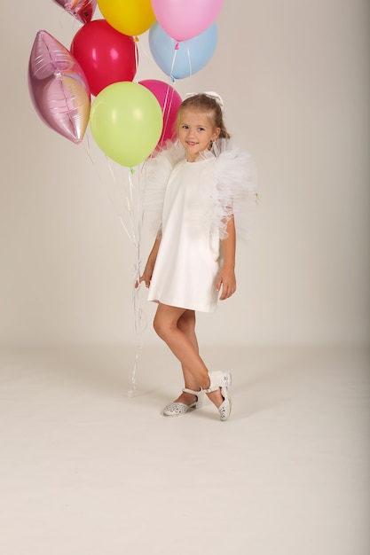 mooi blond meisje in een witte jurk met ballonnen in haar handen vakantie verjaardag