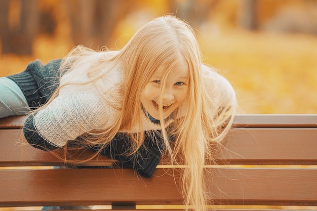 Mooi blond meisje in het park in de herfst