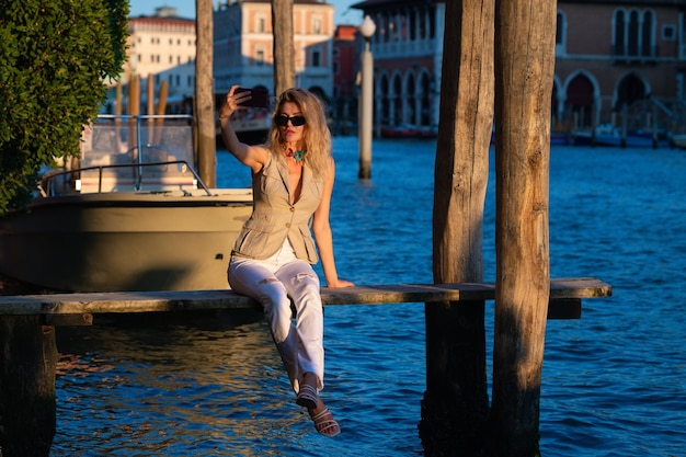 Mooi blond model loopt weg van Venetië Italië straat op vakantie luxe reis in Venetië sexy