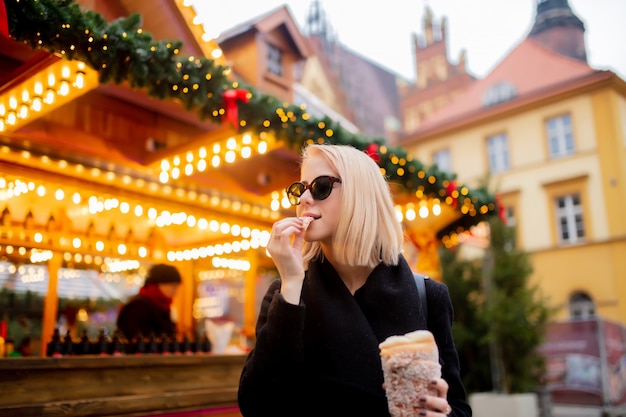 Mooi blonde met spitcake bij de kerstmismarkt in wroclaw, polen