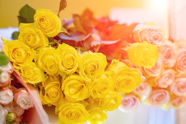 Mooi boeket gele rozen tussen roze bloemen op tafel Verse gele rozen Achtergrond van rozen