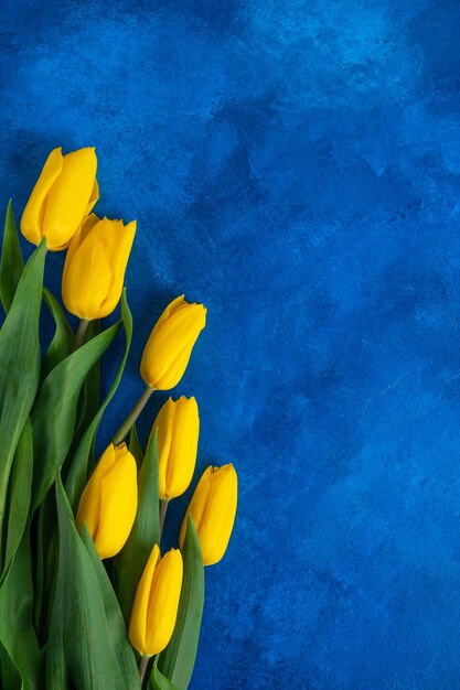 Mooi boeket gele tulpen op een blauwe betonnen achtergrond Bovenaanzicht kopieerruimte