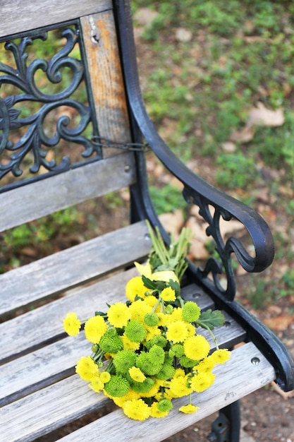 Mooi boeket van chrysanten bloemen op houten bankje in park