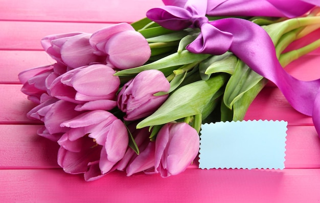 Mooi boeket van paarse tulpen op roze houten achtergrond