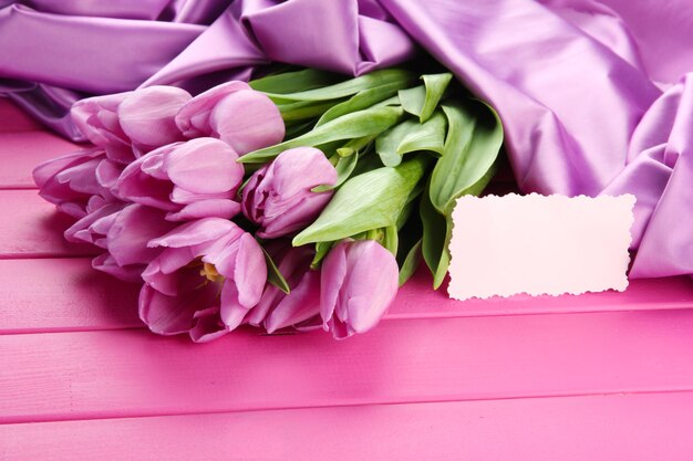 Mooi boeket van paarse tulpen op roze houten achtergrond