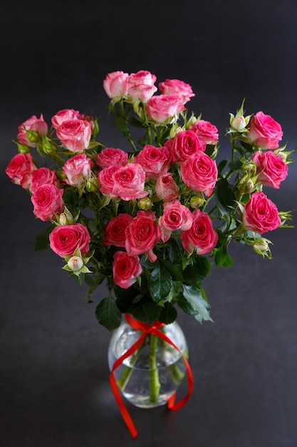 Mooi boeket van roze rode rozenstruiken met waterdruppels op een zwarte achtergrond Selectieve focus close-up
