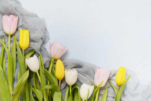 Mooi boeket van veelkleurige tulpen op een blauwe achtergrond. Lentebloemen, cadeau, lente vakantie concept, kopie ruimte