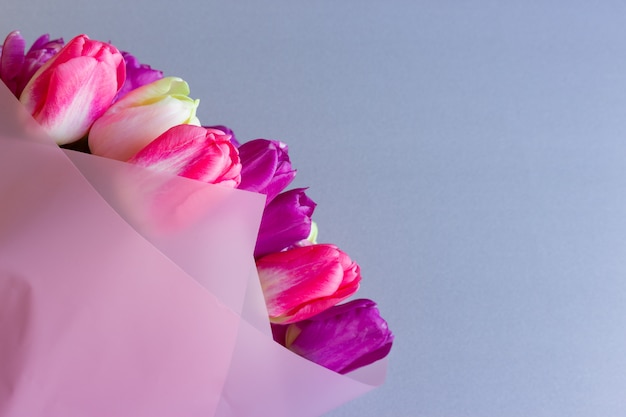 Mooi boeket van verse kleurrijke roze purpere bloemen op neutrale achtergrond