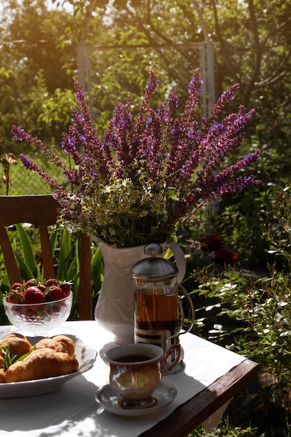 Mooi boeket van wilde bloemen op tafel geserveerd voor het drinken van thee in de tuin