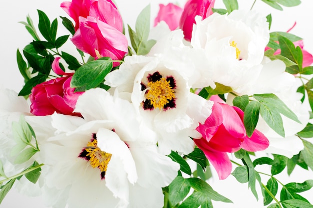 Mooi boeket van witte pioenrozen en roze tulpen in een glazen vaas op een witte achtergrond