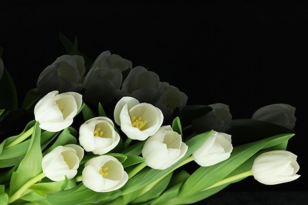 Mooi boeket van witte tulp bloemen met kaart op zwarte achtergrond ruimte voor tekst