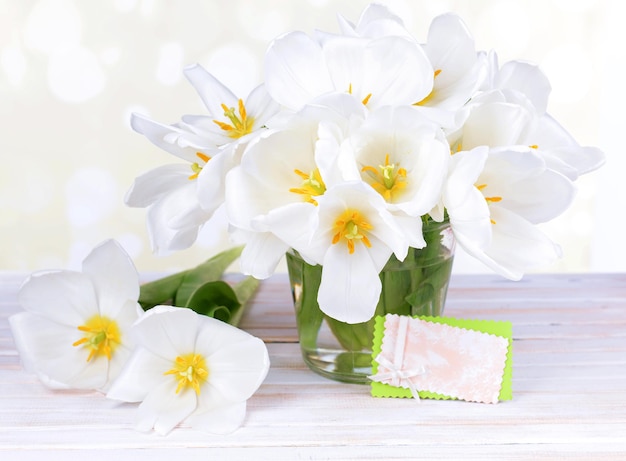 Mooi boeket van witte tulpen op tafel op lichte achtergrond