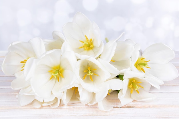 Mooi boeket van witte tulpen op tafel op lichte achtergrond