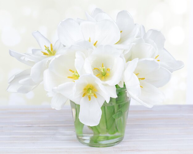 Mooi boeket van witte tulpen op tafel op lichte achtergrond