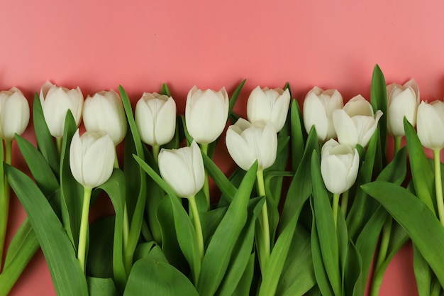 Mooi boeket van witte tulpenbloemen met kaart op roze ruimte als achtergrond voor tekst