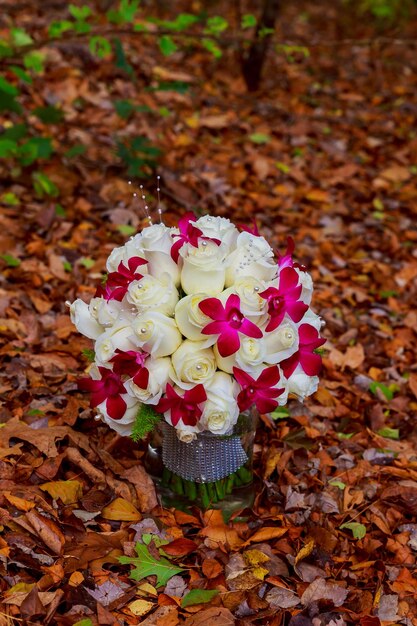 Mooi bruidsboeket bruidsboeket van witte rozen op een achtergrond van bladeren