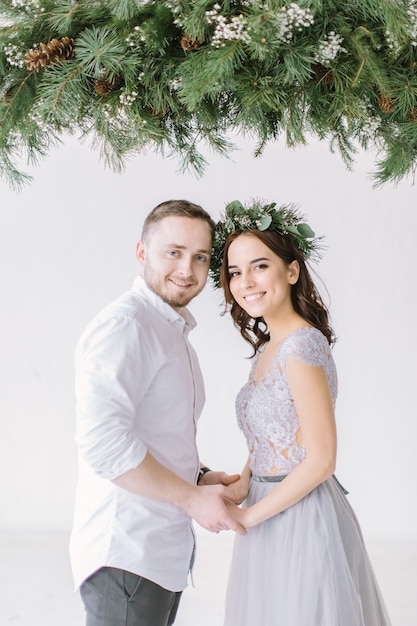 Mooi bruidsmeisje met knappe groomsman in de studio knuffelen