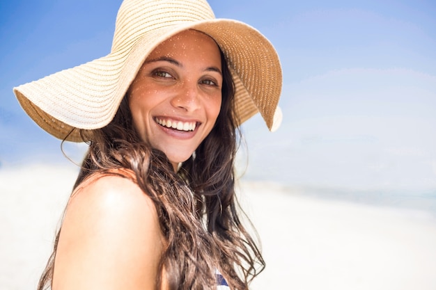 Mooi brunette die camera het strand bekijken