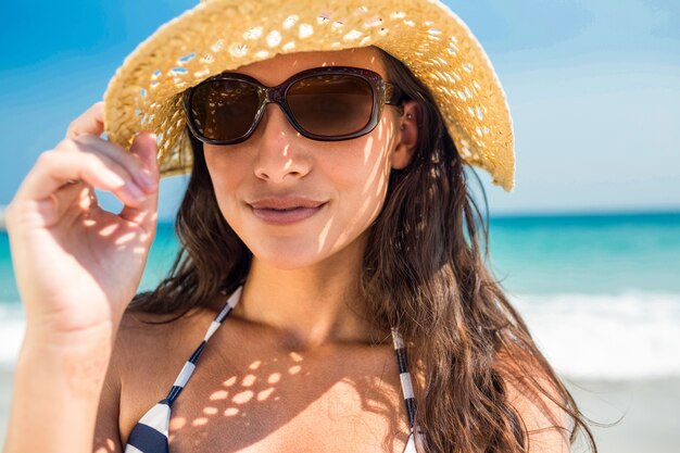 Mooi brunette die camera het strand bekijken