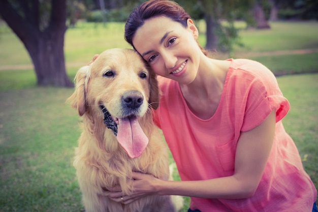 Mooi brunette die camera met haar hond bekijken